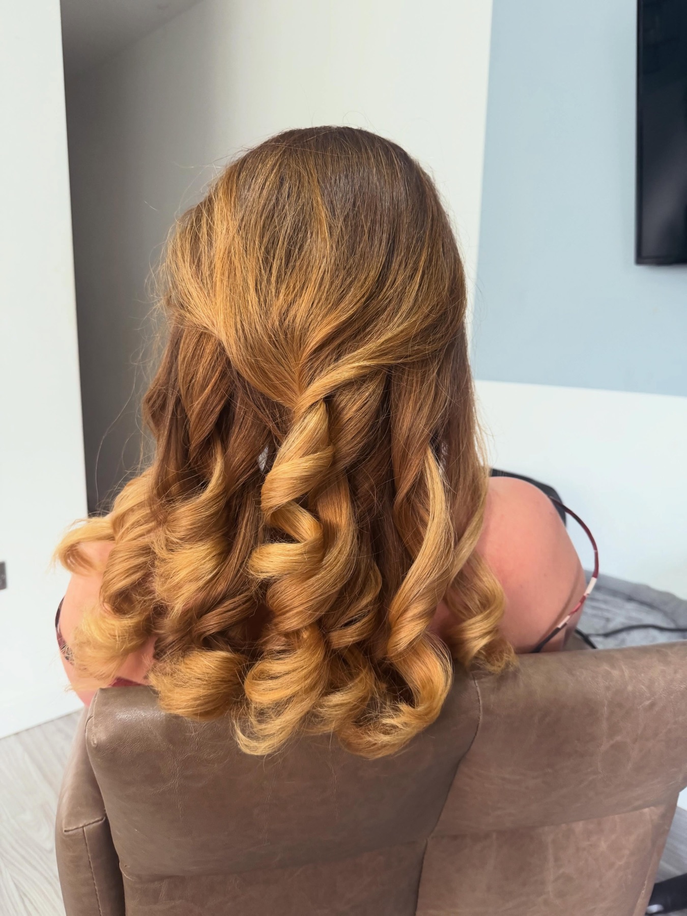 Warm blonde mobile blow dry with soft bouncy curls.
